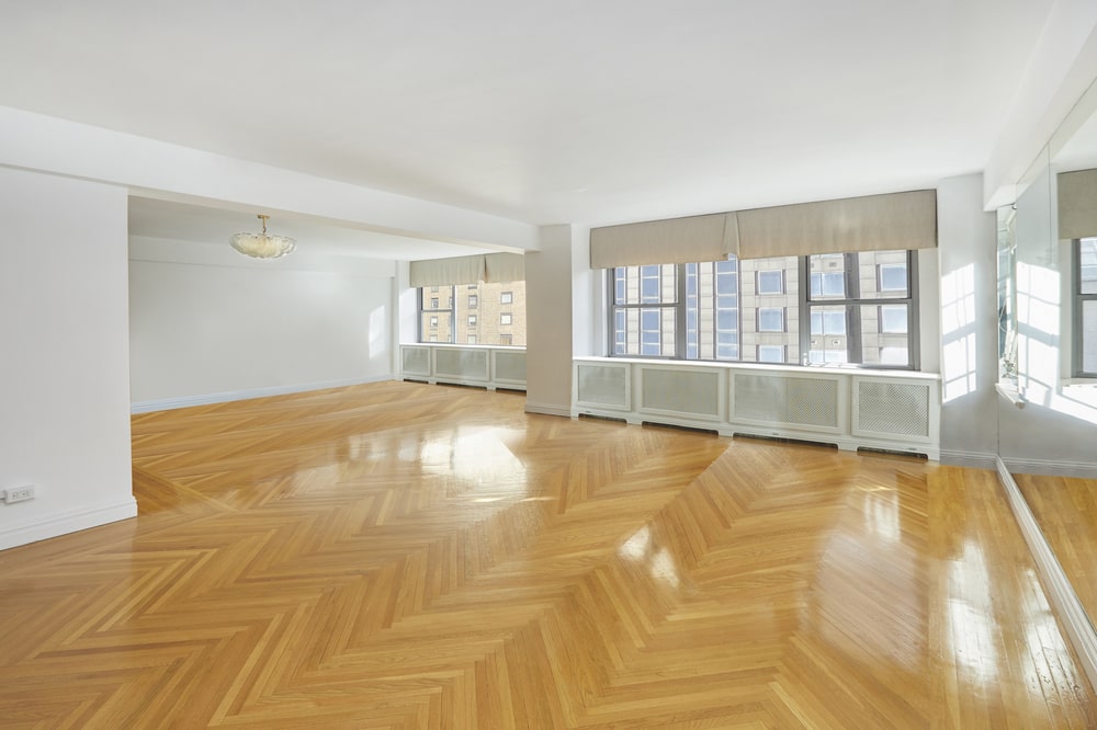 This is the spacious formal dining room with a herring bone hardwood flooring that pairs well with the white walls and ceiling brightened by the windows. Image courtesy of Toptenrealestatedeals.com.