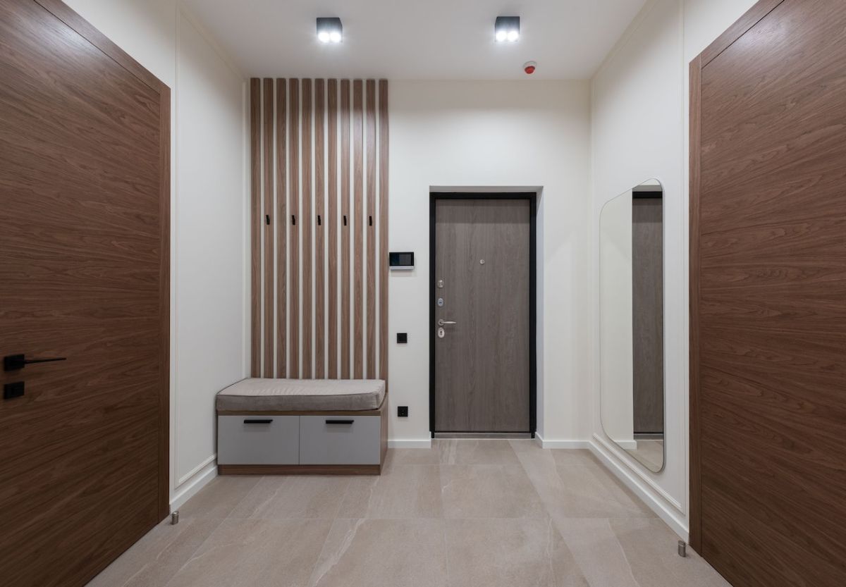 Vertical wood slats add rich texture to this foyer design that highlights the natural stone flooring.