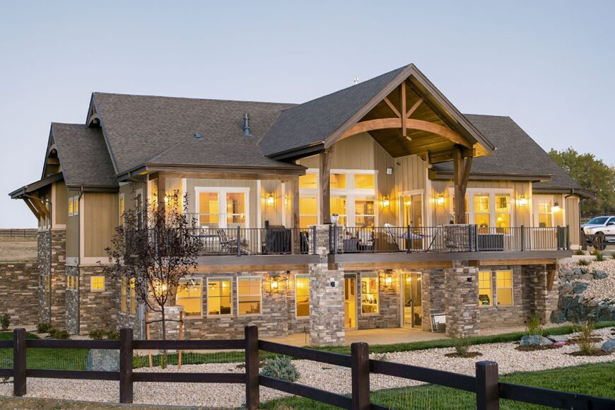 Rear exterior view with covered patio, sun decks, and a gabled porch.