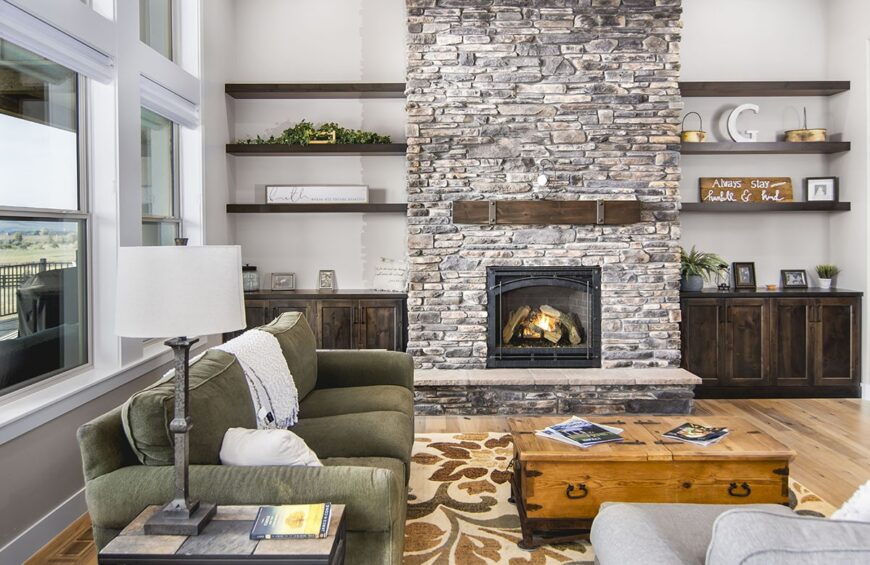 Dark wood built-ins filled with various decors flank the stone fireplace.