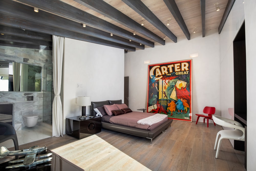 This other bedroom has white walls contrasted by the large colorful wall art beside the bed with bedside tables. Image courtesy of Toptenrealestatedeals.com.