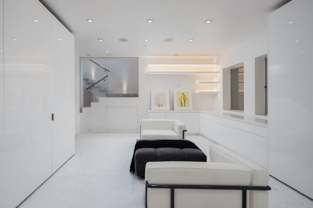 This is the spacious and bright walk-in closet with matching white cushioned chairs. Image courtesy of Toptenrealestatedeals.com.