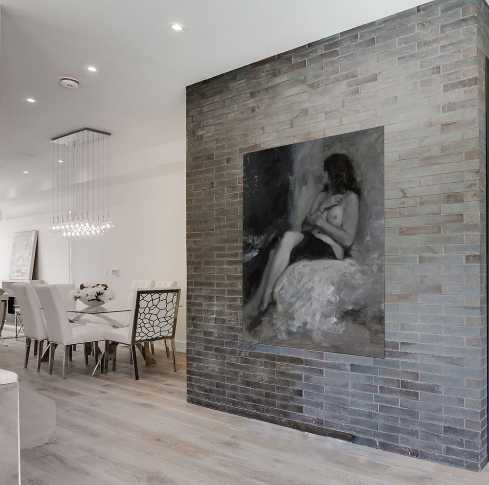 On the side of this living room is a large brick wll adorned with a large wall-mounted artwork that pairs well with the gray tone of the brick wall.