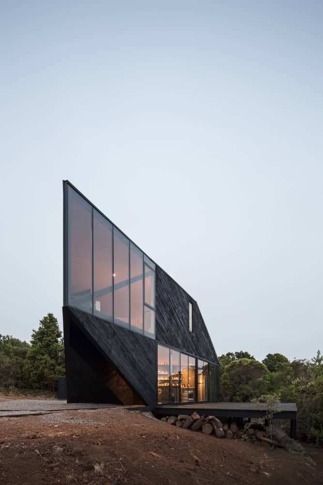 This is a side of the house facing the cliff with a large wooden deck platform that also is perfect for outdoor dining and lounge facing the view.