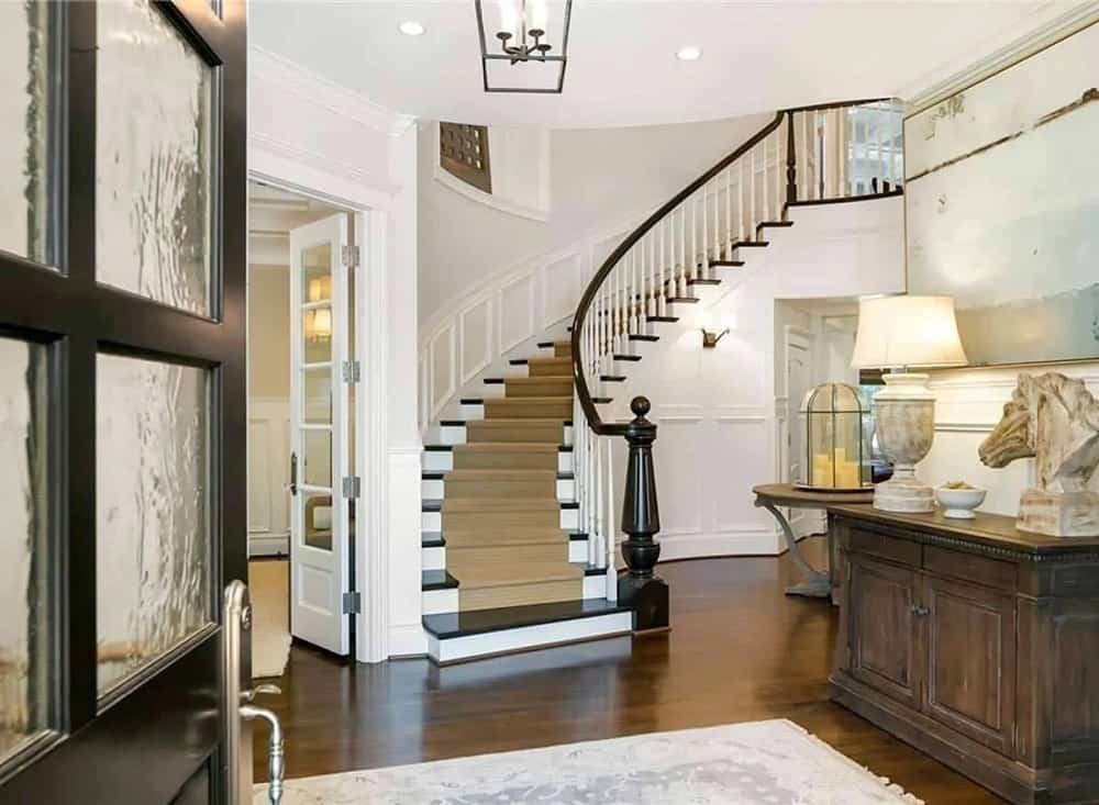 Upon entry of the dark wooden main door, you are welcomed by this foyer that has a dark cabinet topped with decors and a table lamp.