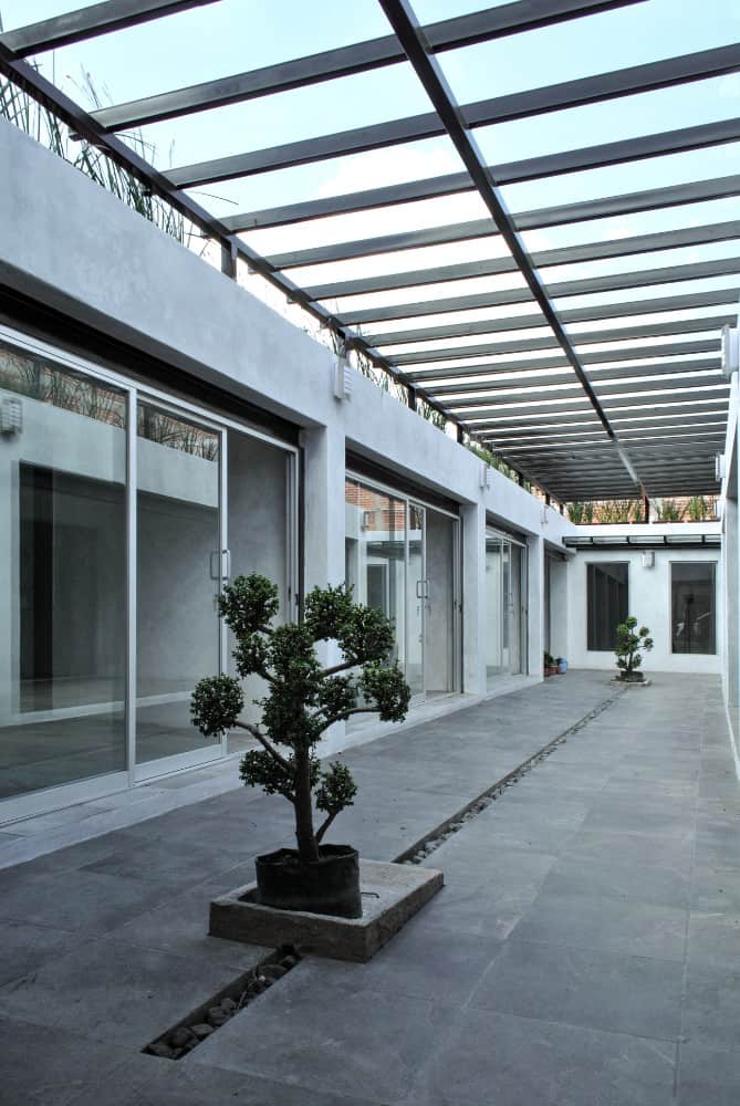 This is another look at the large courtyard inside the gate with potted plants and sets of various glass sliding doors on the sides.