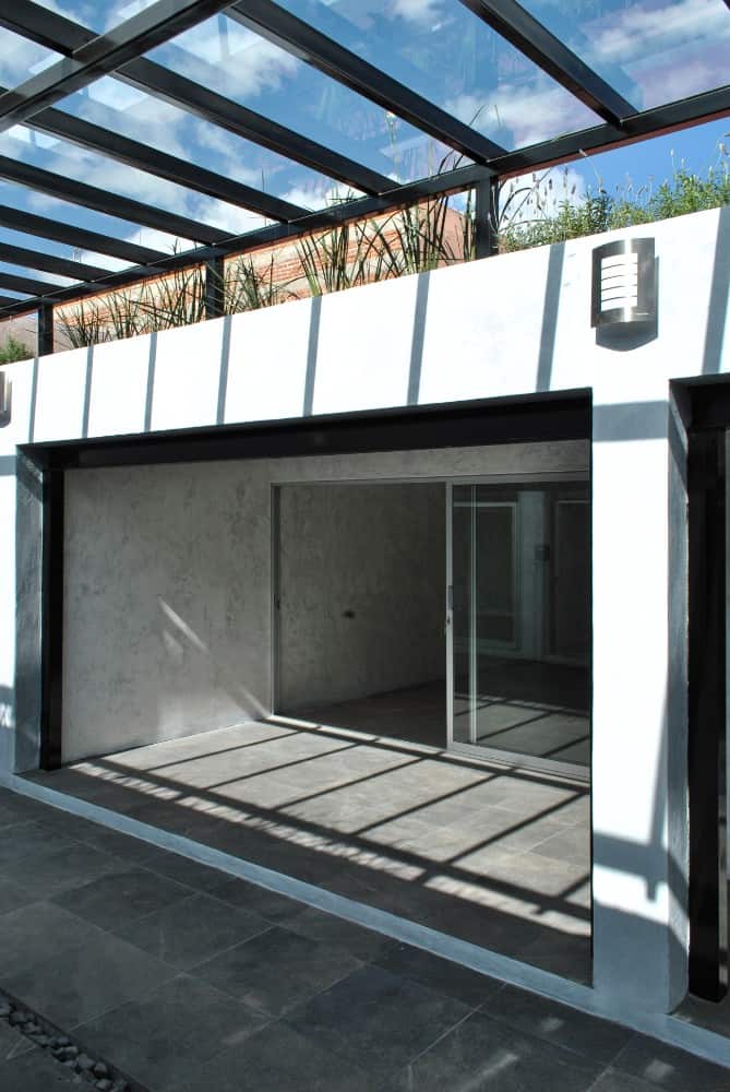 This is a closer look at the covered patio area just beyond the glass doors topped with planters that complement the glass ceiling.