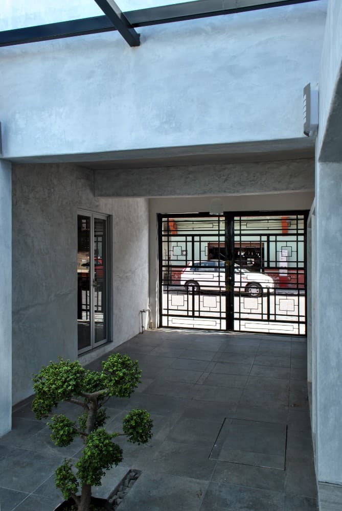 This is a closer look at the driveway of the house and a view of the wrought-iron outer gate and its intricate design.