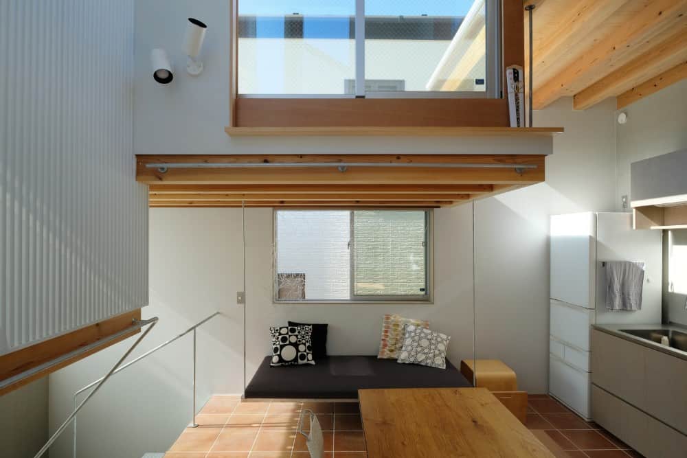 This is another look at the dining area of the house interior showcasing the built-in cushioned bench on the far side under the window.