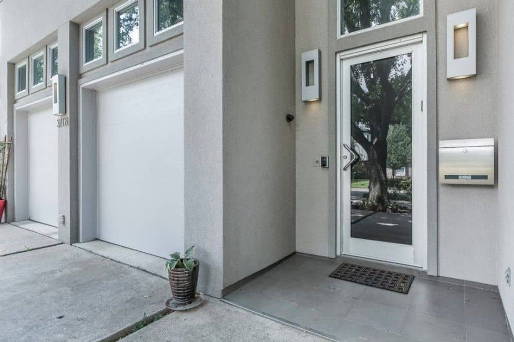 Home entry with a glazed entry door flanked by modern sconces.