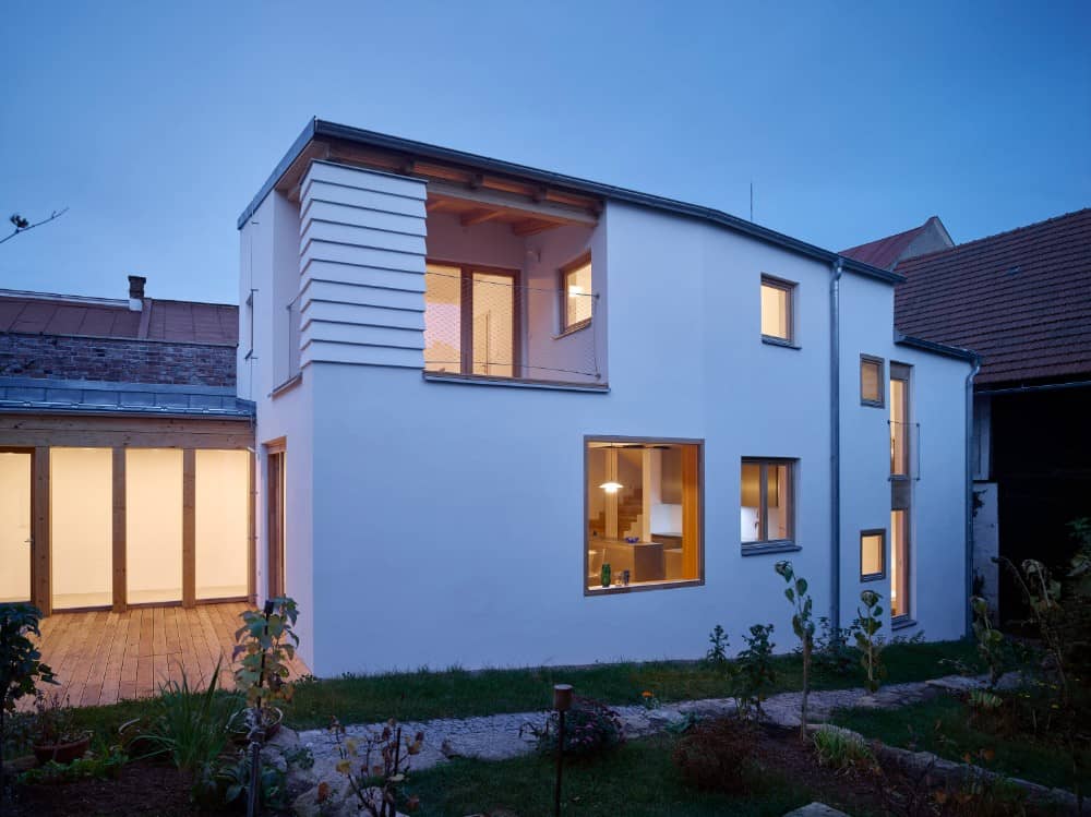 Stunning exterior shot of lighted house of courtyard by Igloo.