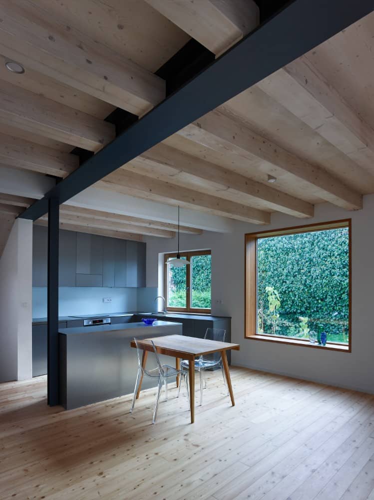 Interior shot of kitchen area showing its opened black beam and gray kitchen accent.