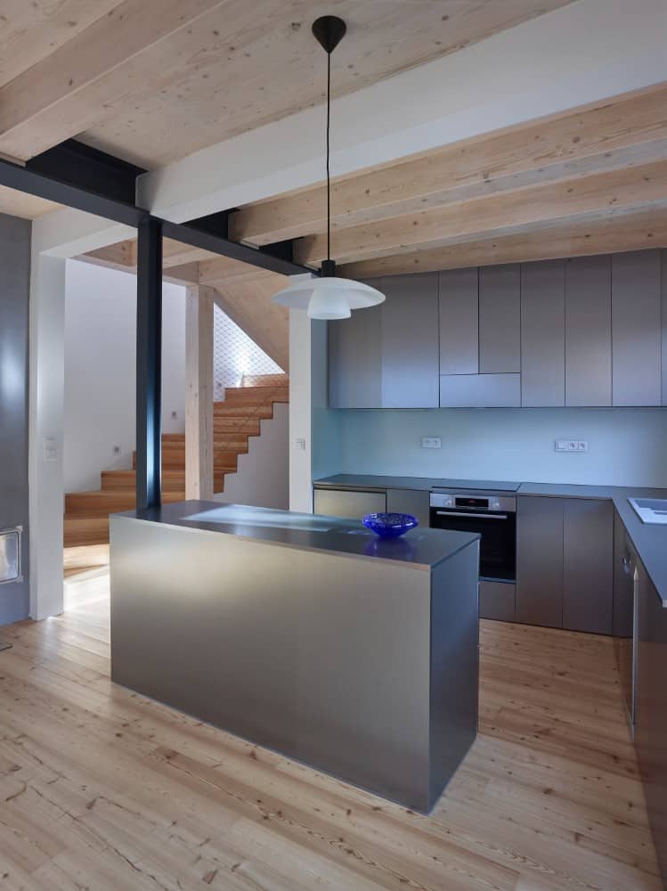 Interior shot in kitchen area showcasing its hanging lights and gray kitchen accents.