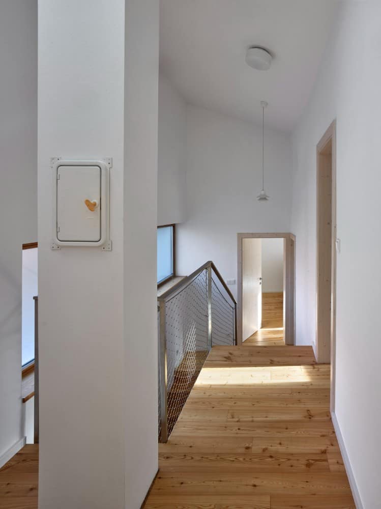 Interior shot of narrow downstairs with aluminum railings.