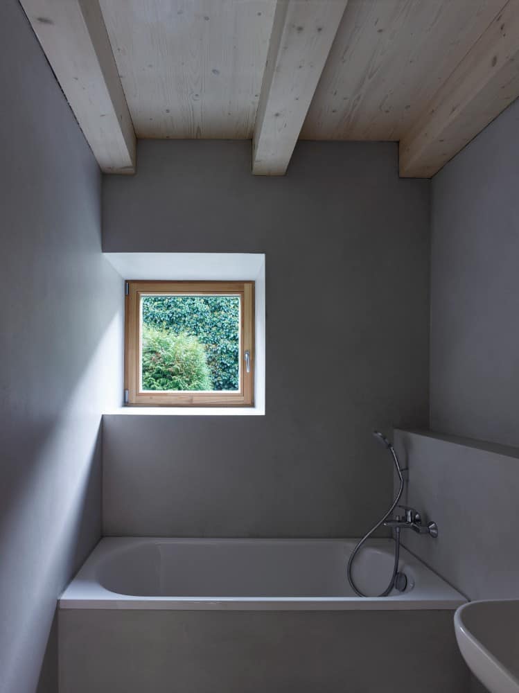 Interior shot of a small bathroom section painted of gray in wall.