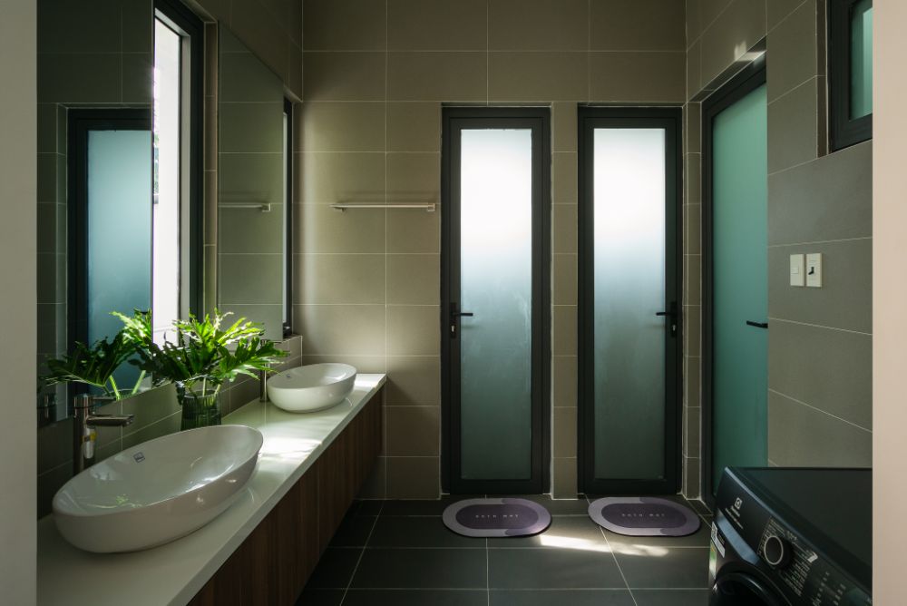 Bathroom with two table-top oval white sink, full length mirror and two doors to shower room.