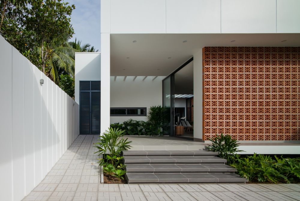 House outside view with balcony in terracotta ventilation brick wall and sliding glass door.