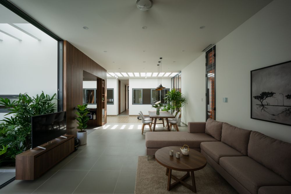 Living area with T.V, small rounded center table, cushioned sofas, and floor rug.