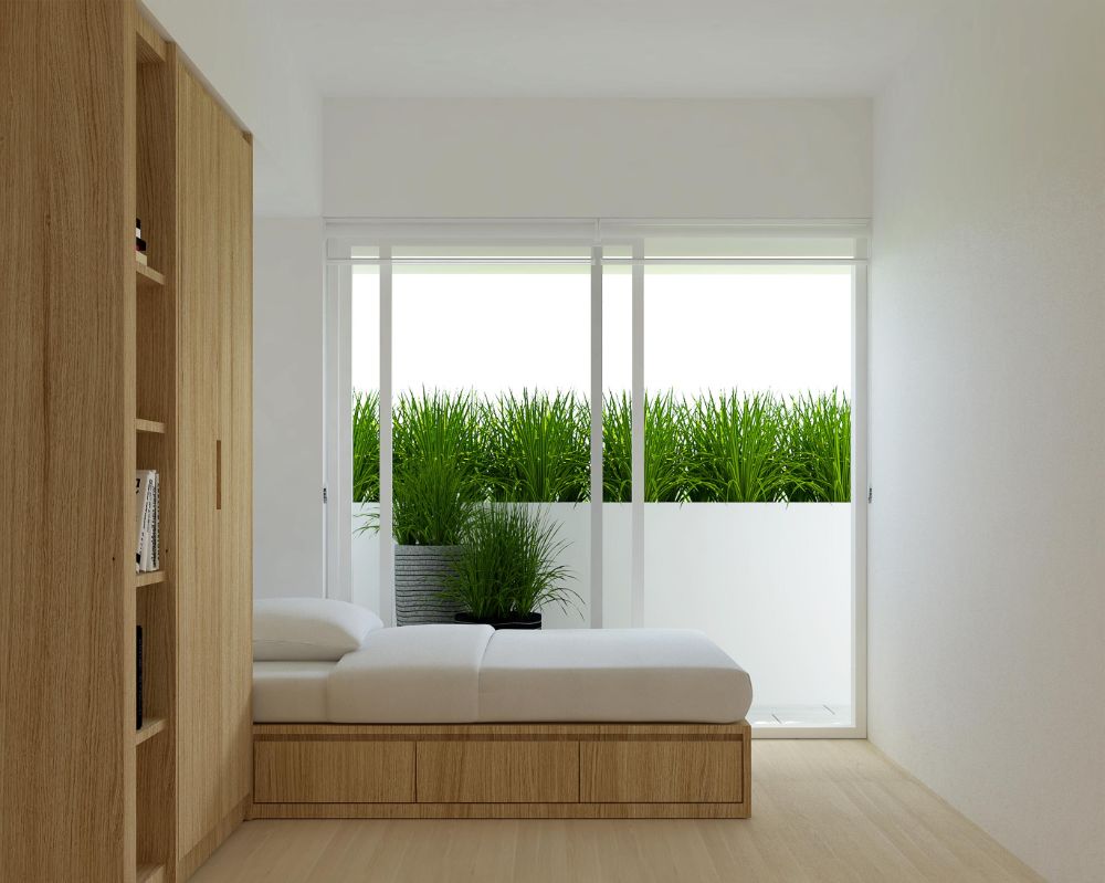 Bedroom with oak wood bed, cabinet, and floor, sliding glass door leading to terrace with ornamental grass plants.