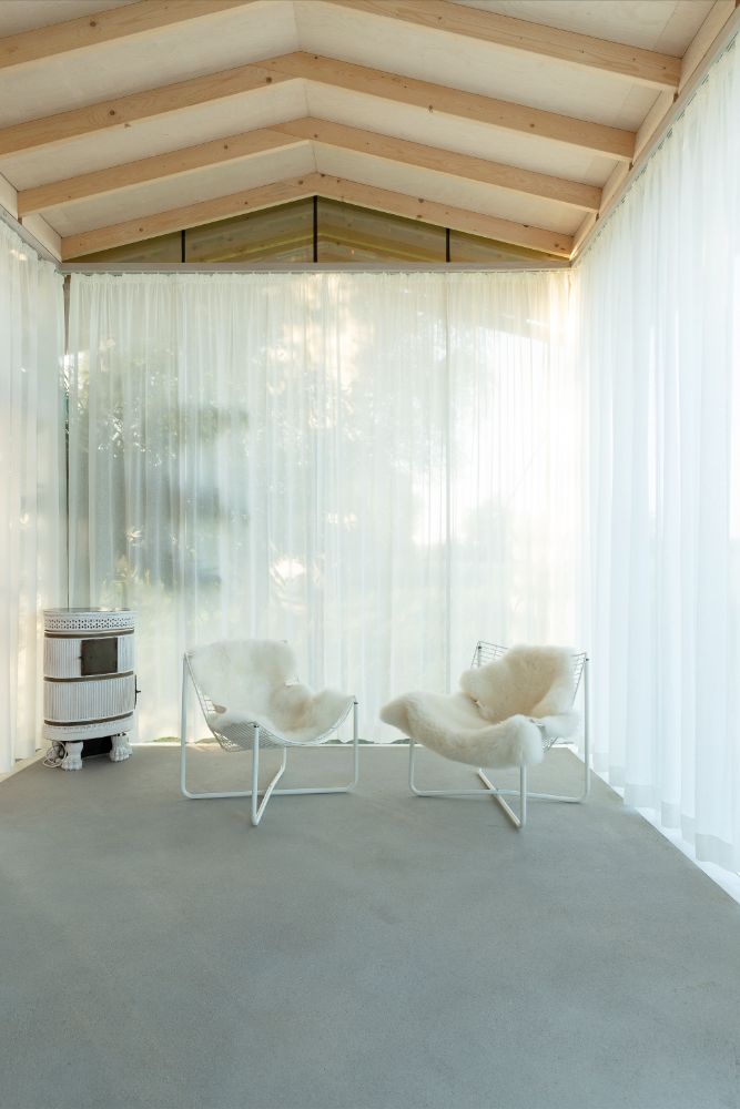 The living area with two fur faux chair in a glazed that makes the inside and outside boundary becomes blurred.