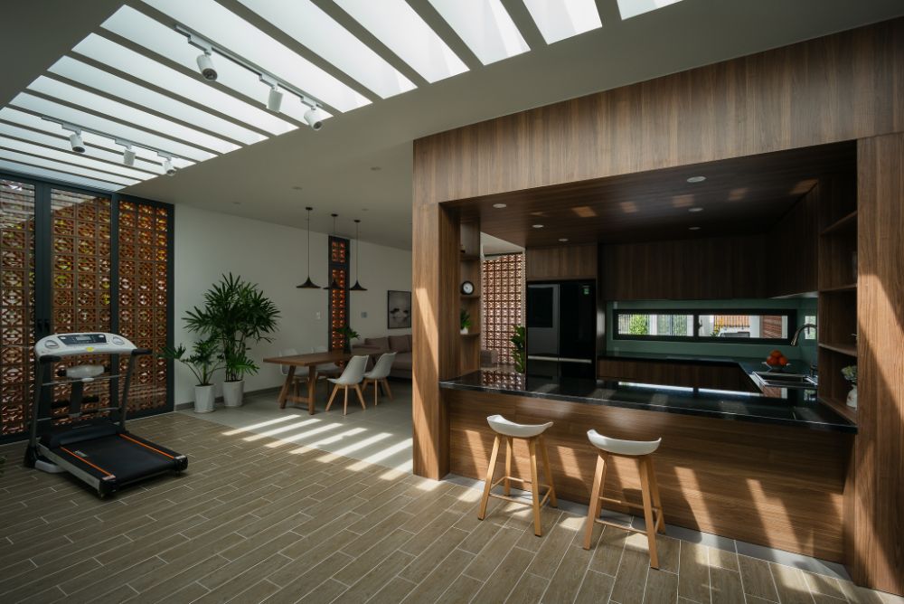 Kitchen area with two bar type chairs, beside exercise and dining area.