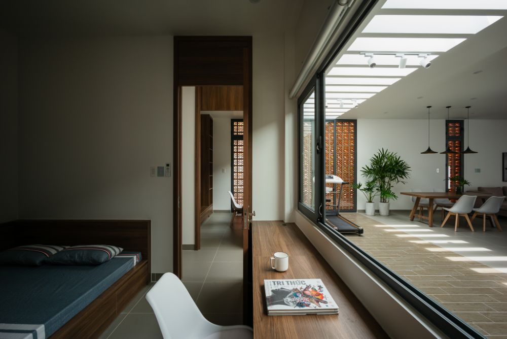 Bedroom with open sliding window leading to view the exercise and dining area.