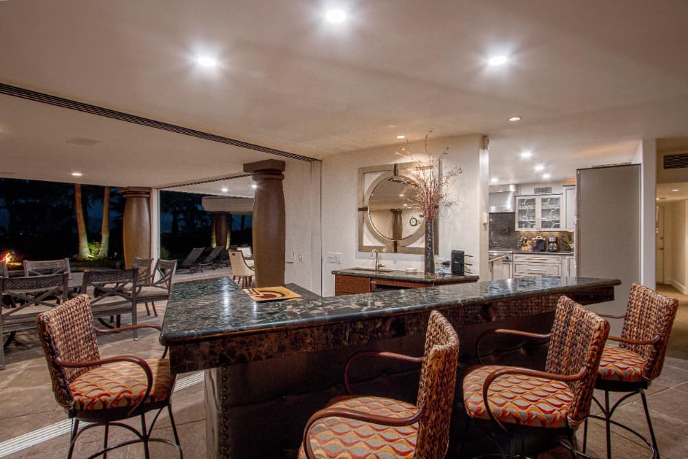 The bar has a raised snack counter and four contemporary stools. Image courtesy of Toptenrealestatedeals.com