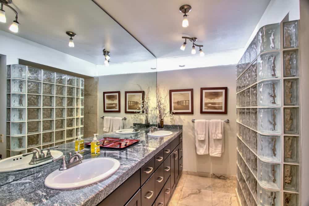 Another bathroom with dual sink vanity and a walk-in shower enclosed in glass bricks. Image courtesy of Toptenrealestatedeals.com