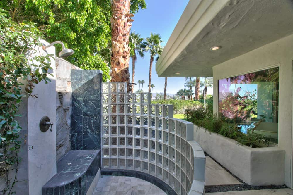 The house also includes a nice outdoor shower with a tiled bench and glass block walls. Image courtesy of Toptenrealestatedeals.com