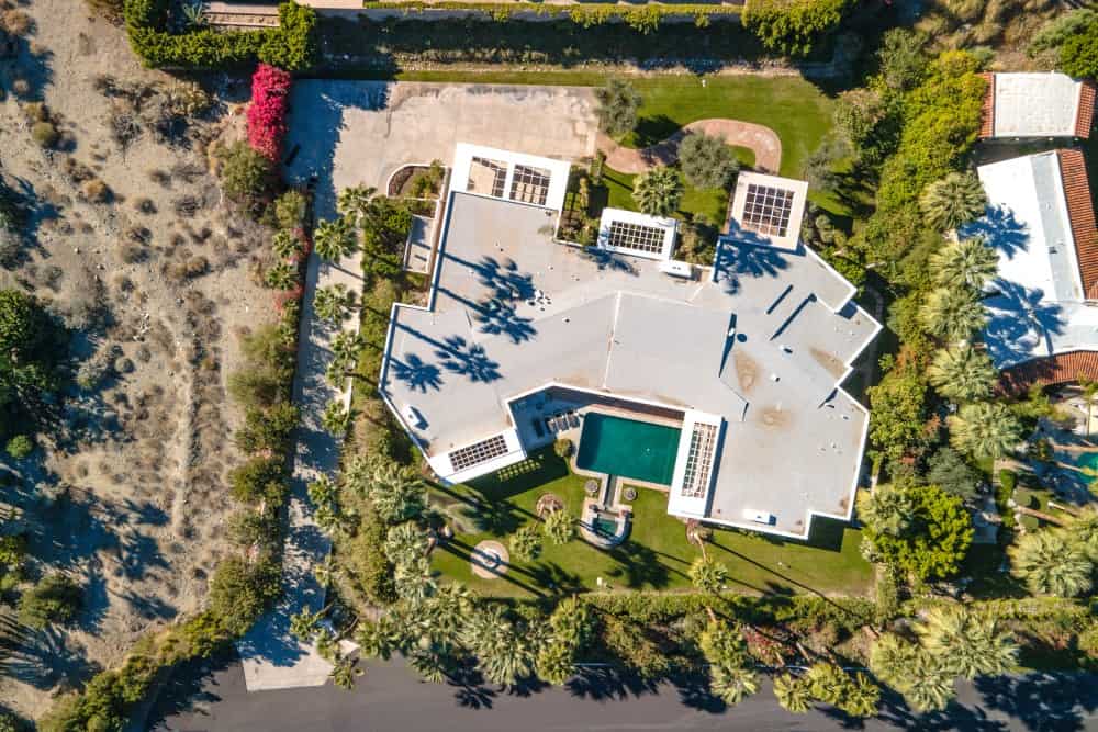 Aerial view of the sprawling estate surrounded by mountains and lush greenery. Image courtesy of Toptenrealestatedeals.com