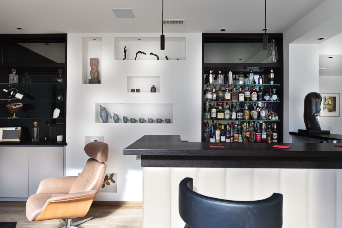 The bar area with tile-topped counter and a variety of wine on shelves.