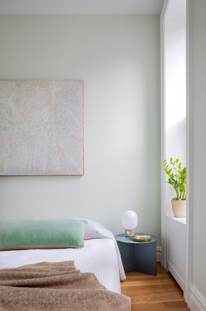 The master suite has high ceilings and a sculptural hall skylight and the walls in the bedroom are painted in Farrow and Ball Green Blue.