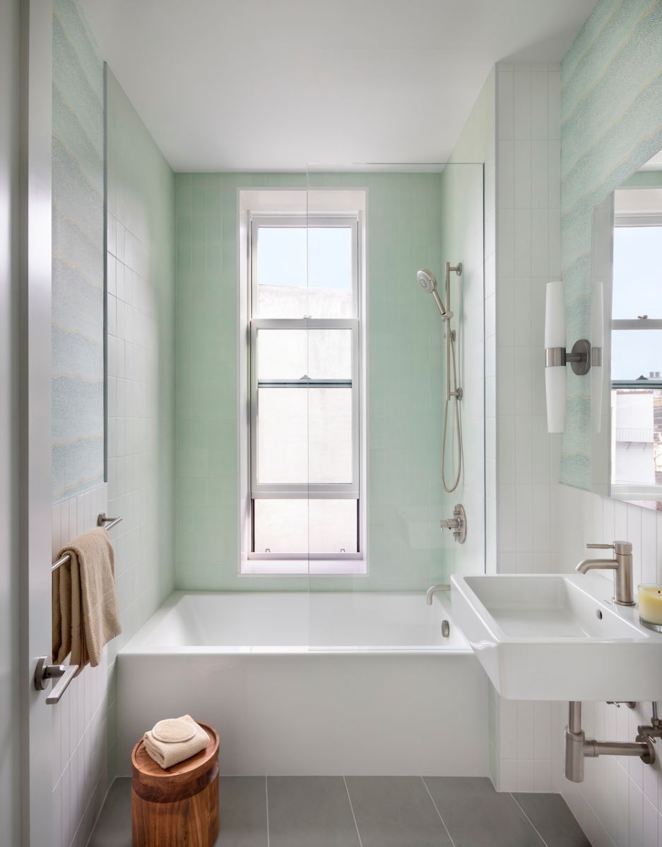 The skylit master bath has a Perlato solid surface tub, Farrow and Ball Yukutori wallpaper, and Vermeere hex mosaics in the shower.