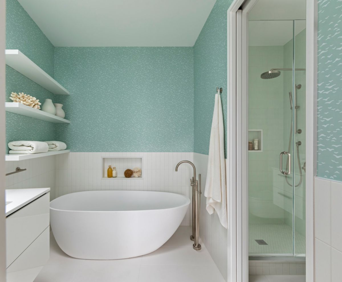 The skylit master bath has a Perlato solid surface tub, Farrow and Ball Yukutori wallpaper, and Vermeere hex mosaics in the shower.