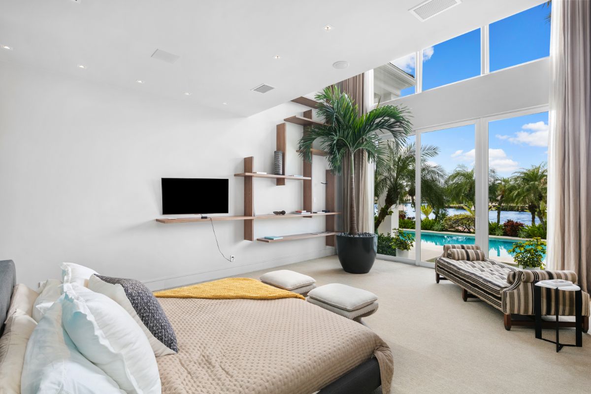 Modern design master bedroom with full height glass wall facing the river.