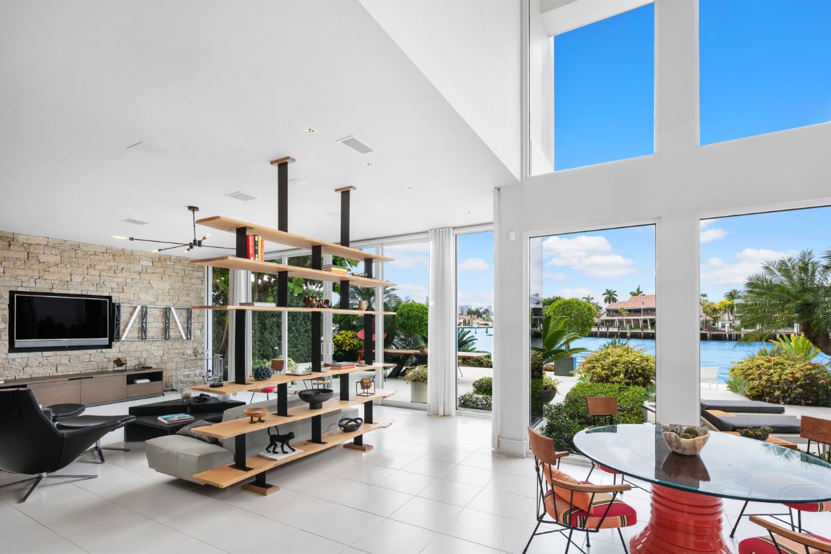 Two story breakfast area with rounded glass table and wall.