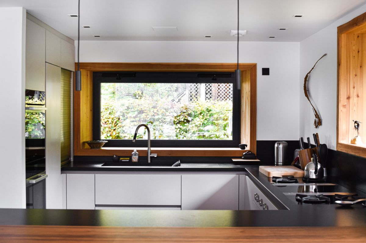 The kitchen area with tile-topped sink and built-in kitchen appliances.