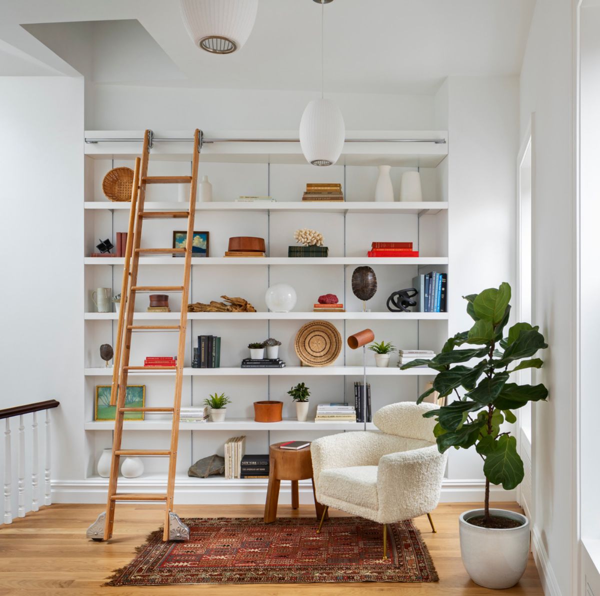 The library area includes a full-height shelving wall and a library ladder that also serves as roof access.