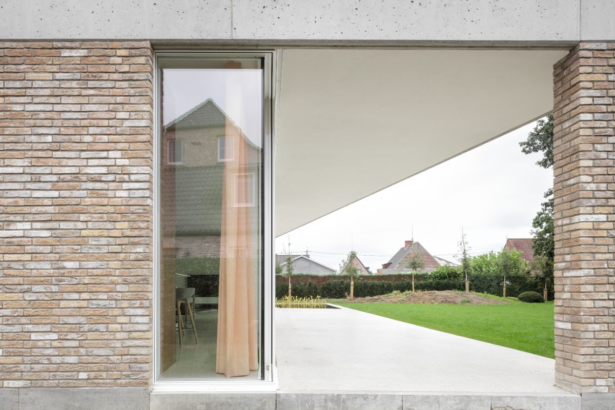 Outside view of the of the full height glass and bricks wall leading to the dining area.