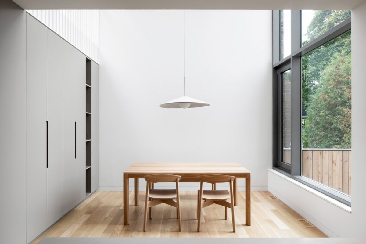 The dining room that offer a direct view of the courtyard through the glass wall.