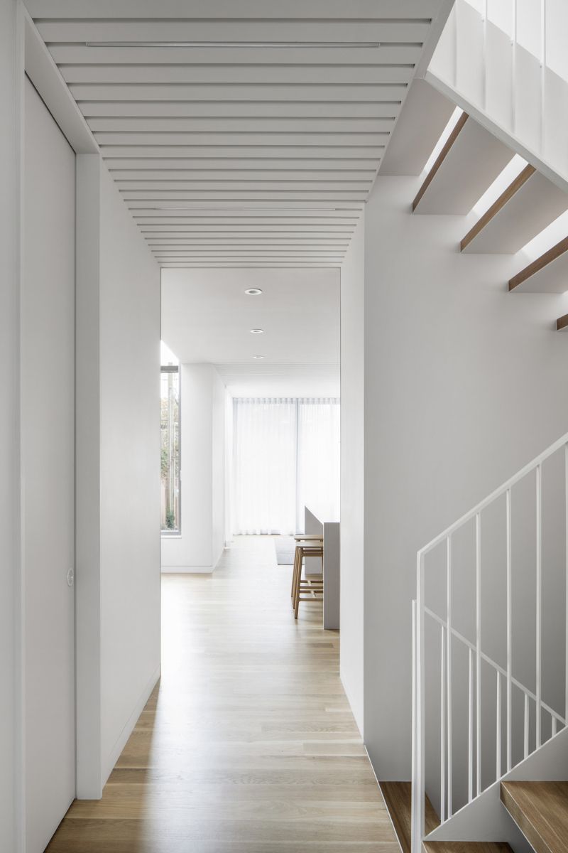 The zigzag stairs with steel railings connected to the kitchen.