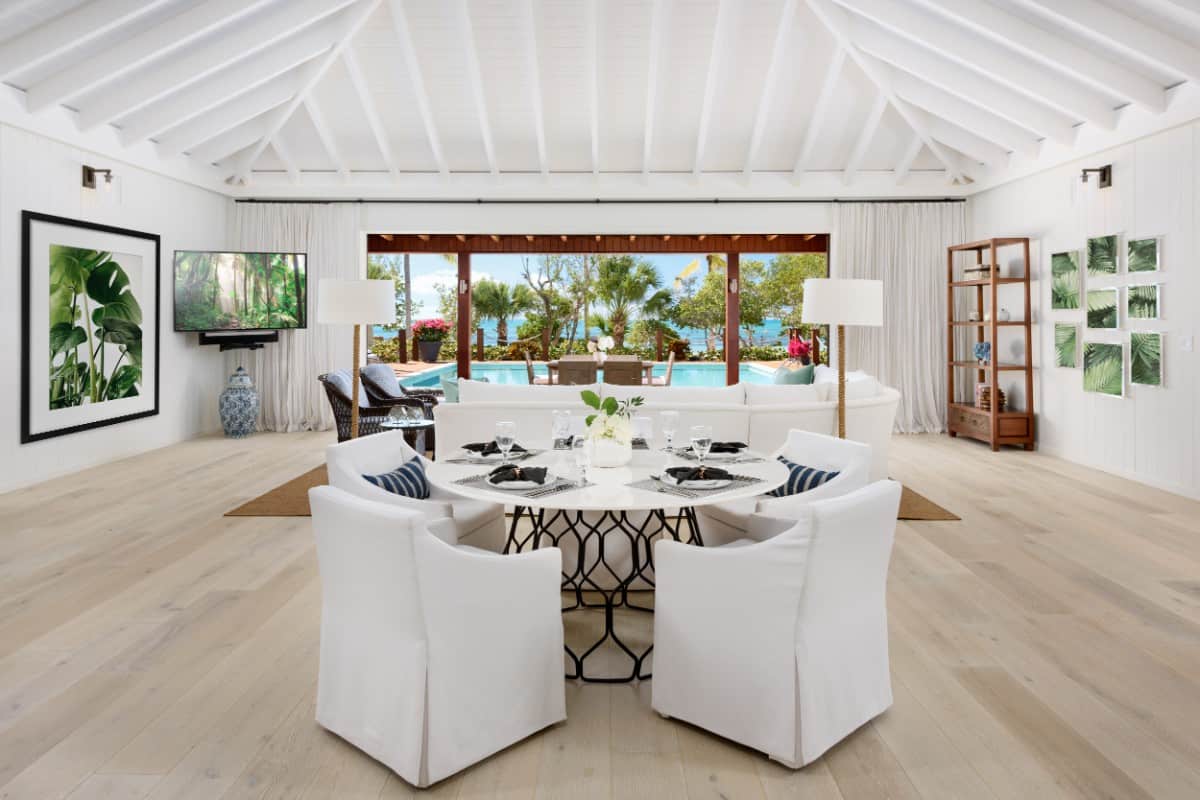 Main residence dining room with a contemporary round table paired with skirted armchairs. Image courtesy of Toptenrealestatedeals.com.