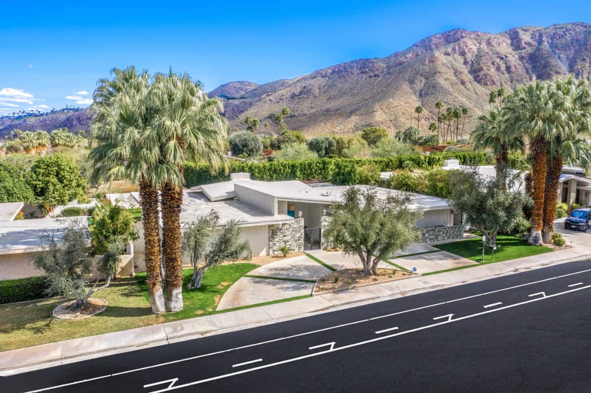 Aerial front view of the sprawling house with stucco exterior accentuated with beautiful stones. Image courtesy of Toptenrealestatedeals.com.