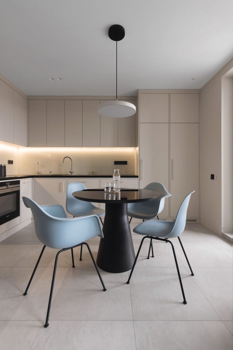 The dining area concrete dining table in accent blue chairs and stainless steel cantilever shelf.