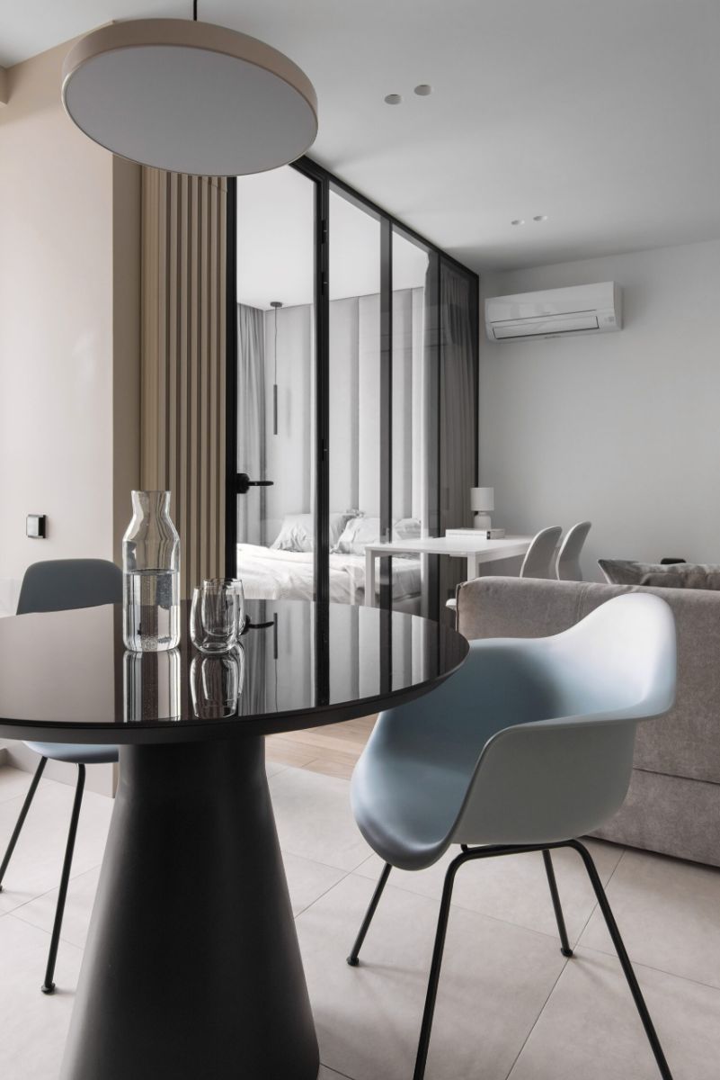 The dining area concrete dining table in accent blue chairs and a view of the park outside.