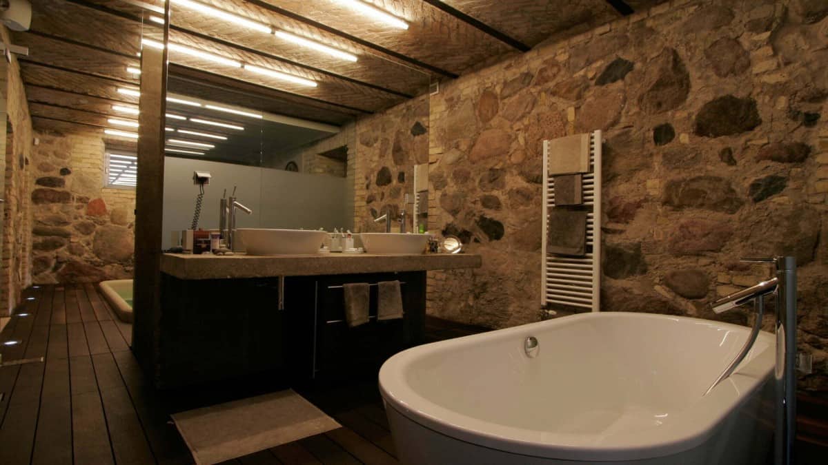 The bedroom is paired with a magnificent bathroom that's clad in stones and bricks.