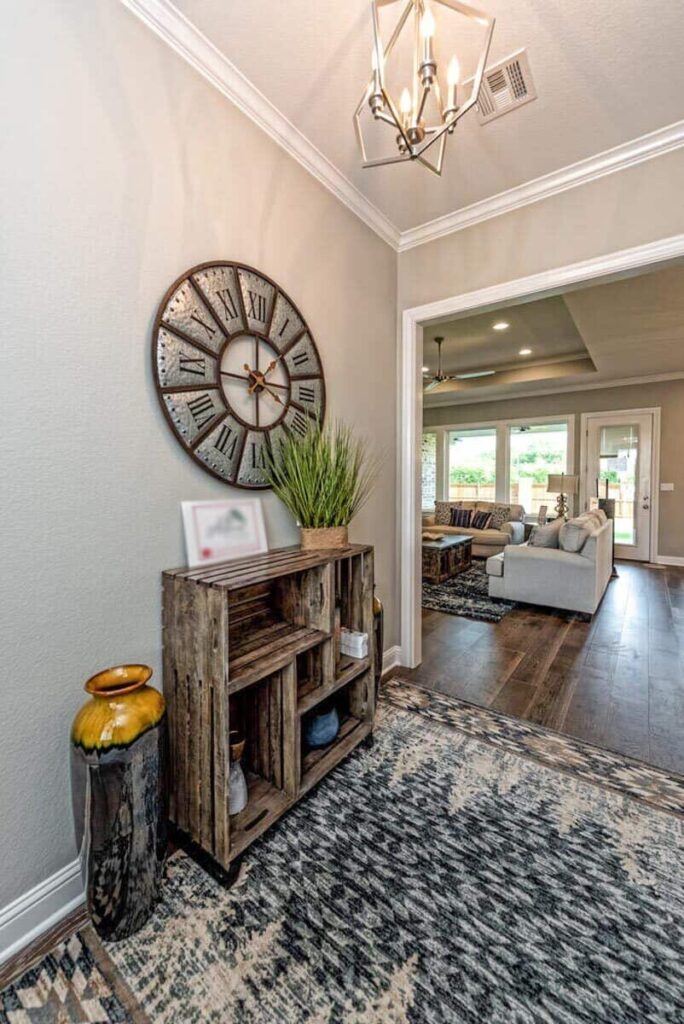 The foyer features a rustic cabinet topped with a round wall clock.