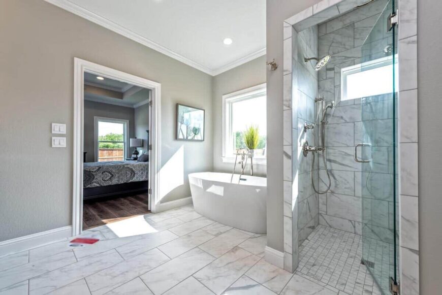 The primary bathroom includes a freestanding tub and a walk-in shower with marble tiled walls and chrome fixtures.