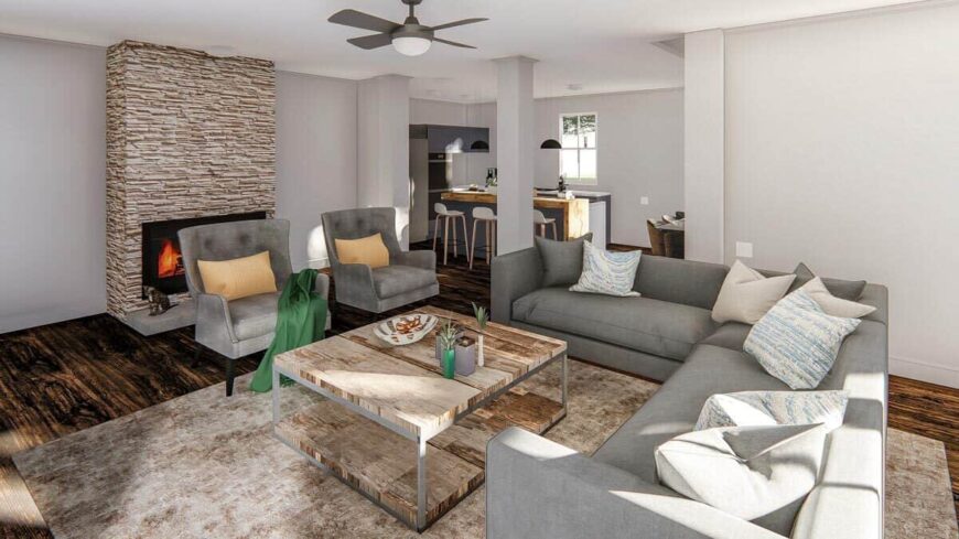 Living room with a stone fireplace, an L-shaped sofa, and matching wingback chairs.