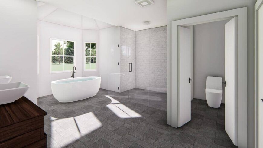 The primary bathroom is bright and spacious. It has a toilet room, a walk-in shower, and a freestanding tub.